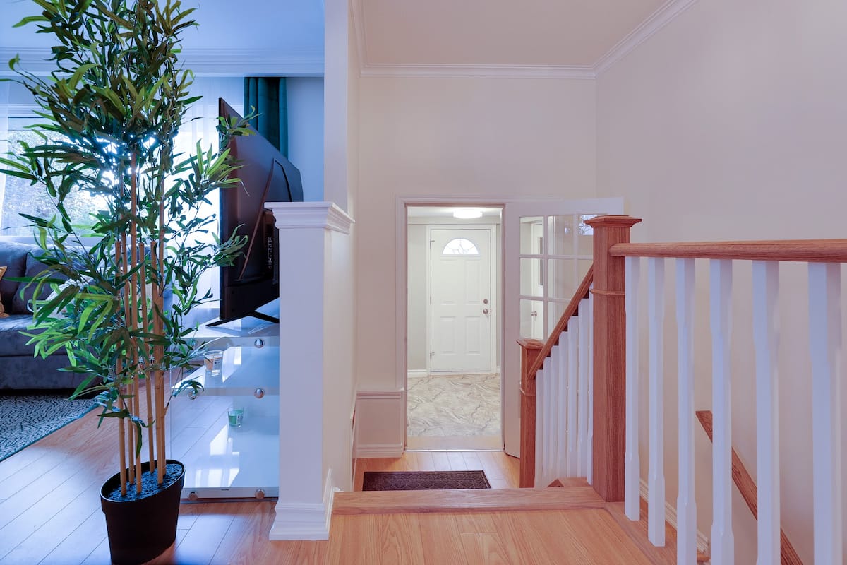Bright entryway and staircase with wood railing