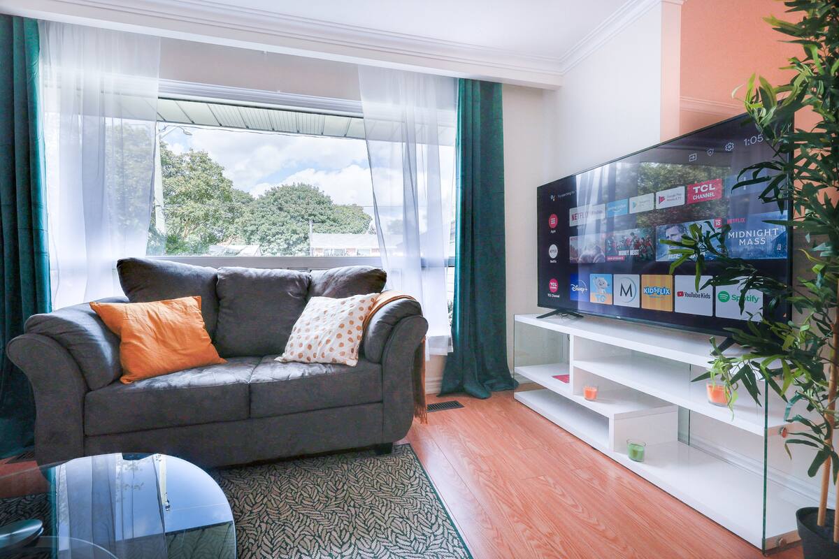 Cozy sitting area with television and a large window at Adored Place